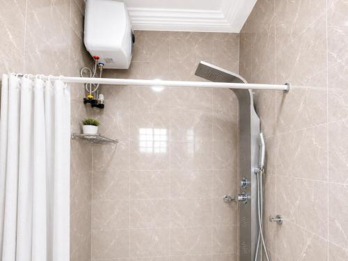 a bathroom with a shower with a shower curtain at Naso Luxe Homes in Sakumona