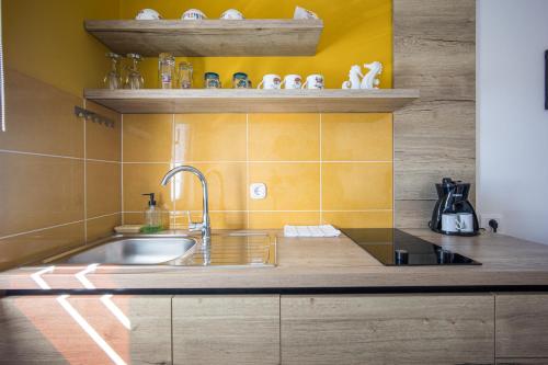 eine Küche mit Spüle und gelber Wand in der Unterkunft Villa Marea in Rovinj