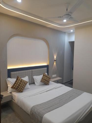 a bedroom with a large white bed with pillows at Hotel Rudrax in Waghoria