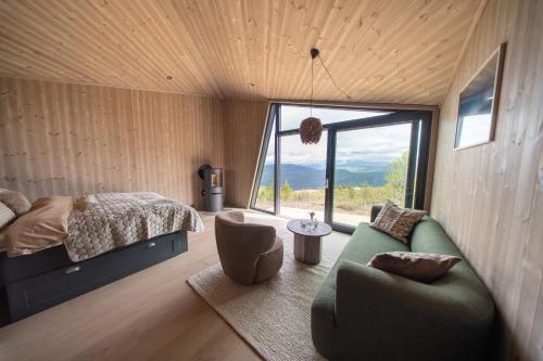a bedroom with a bed and a couch and a window at Hylja Lodge in Vaga
