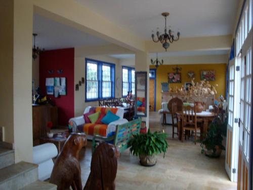 a living room with two dogs and a dining room at Pousada Berço da Liberdade in Tiradentes