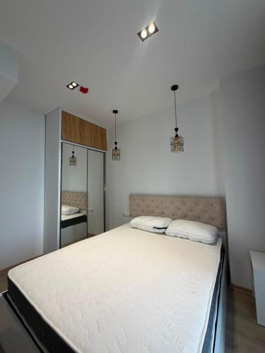 a bedroom with a large white bed with a mirror at Apartment in Gonio in Kvariati
