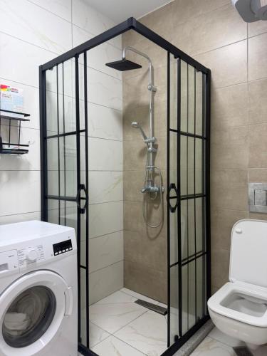 a bathroom with a shower and a washing machine at Apartment in Gonio in Kvariati