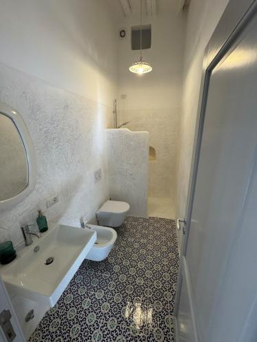 a bathroom with a white sink and a toilet at Il Portico sul mare in Santa Marina Salina