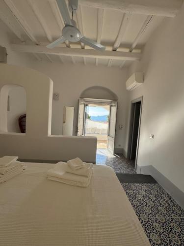 a bedroom with a bed and a ceiling fan at Il Portico sul mare in Santa Marina Salina