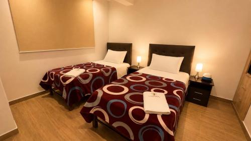 two beds in a hotel room with two at OXALAND HAUs in Oxapampa