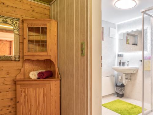 a bathroom with wooden walls and a sink and a mirror at Hintermühltalhof in Itter