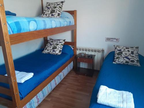 a bedroom with two bunk beds with blue sheets at Alojamiento Punta Arenas in Punta Arenas