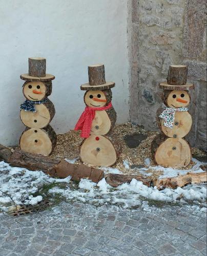 a group of four snowmen in front of a wall at Appartamento Masi in Lasino