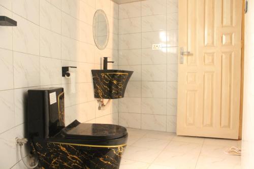 a bathroom with a black and gold toilet at Gejja Cottage in Lwanga