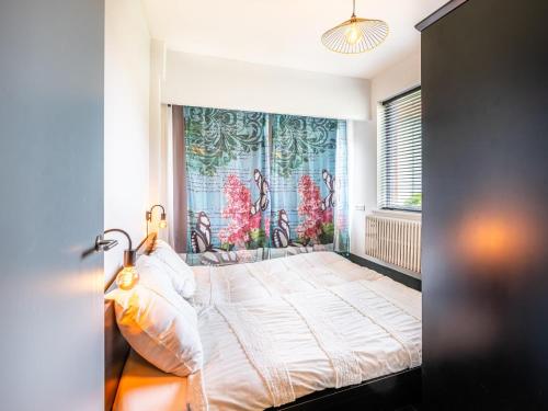 a bedroom with a large bed and a large window at La Terrasse in Sint-Idesbald