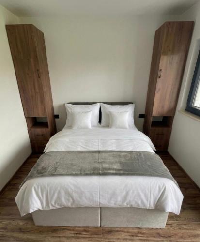 a bedroom with a large white bed with wooden headboards at Villa ZANS in Gradačac