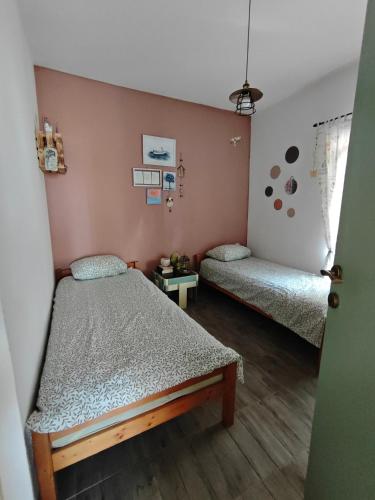 two beds in a room with pink walls and wooden floors at Seaside secluded apartments Cove Skozanje, Hvar - 14899 in Gdinj