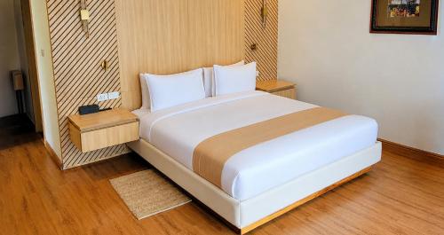 a large white bed in a room with wooden floors at Denbi Eco Lodge in Greater Aman
