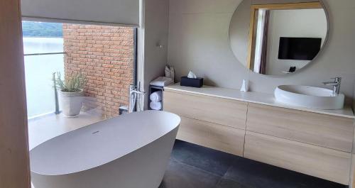 a bathroom with a white sink and a mirror at Denbi Eco Lodge in Greater Aman