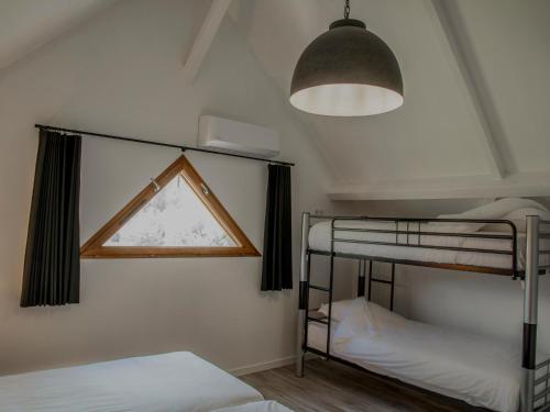 a bedroom with two bunk beds and a window at Lac Bleu 39 in Lacapelle-Marival