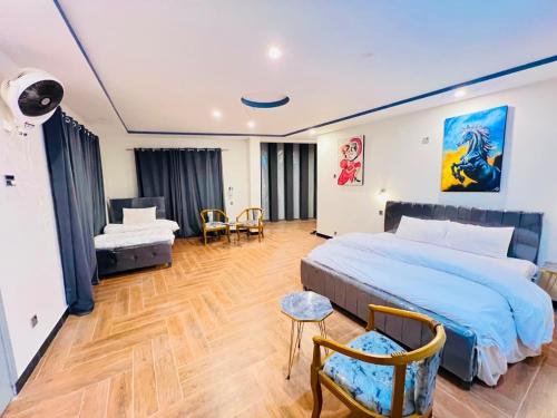 a bedroom with a king sized bed and a chair at Stay O'clock Hotel Skardu in Skardu