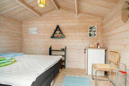 a bedroom with a bed in a wooden cabin at 5020-Askeby-Faergensvaenge-18 in Askeby