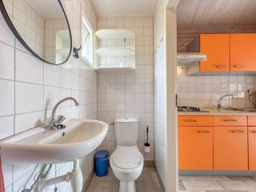 a bathroom with a toilet and a sink and a mirror at Bleubird in Ellemeet