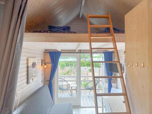 a bunk bed in a tiny house with a balcony at Bleubird in Ellemeet