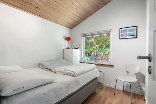 a bedroom with a bed and a window at fj1203-Jaegerspris-Birkagervej-14 in Jægerspris