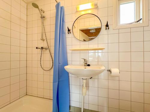 a bathroom with a blue surfboard next to a sink at Surfers Cabin in Ellemeet