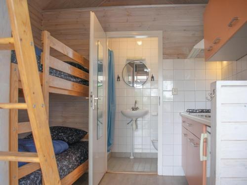 a small bathroom with a bunk bed and a sink at Sea Blue in Ellemeet