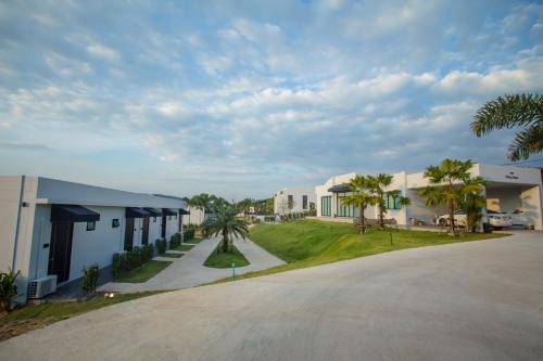 an empty street in a resort with palm trees and buildings at Belong Jin The Dam Hotel And Resort in Ban Pha Saeng Lang