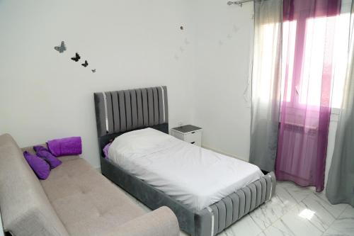 a small bedroom with a bed and a couch at Paradis house in Oran