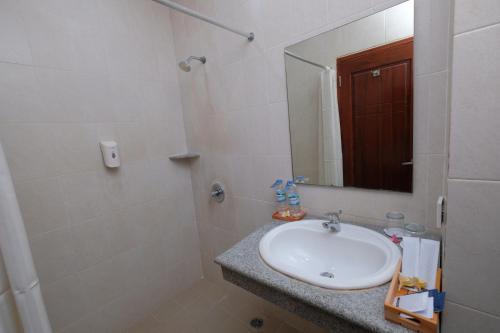 a bathroom with a sink and a mirror at Lampion Hotel Solo in Grogol
