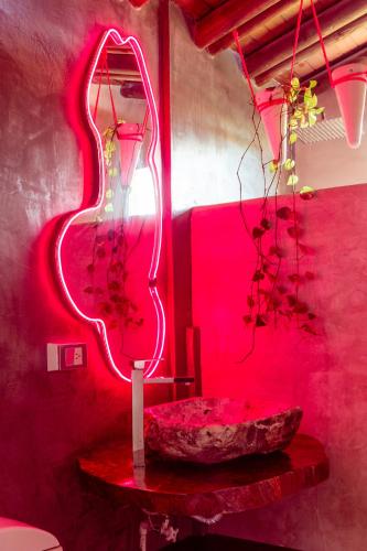 a red room with a mirror and a rock on a table at Melo Capurganá Social Hostel in Capurganá