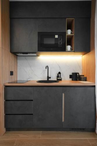a kitchen with a sink and a microwave at Panorama Mountain Tara in Kaludjerske Bare