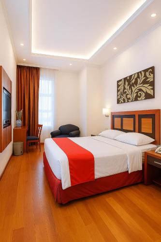 a hotel room with a large bed and a television at Lampion Hotel Solo in Grogol