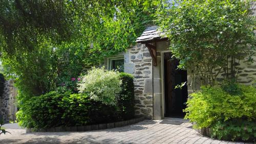 a stone house with a door and some plants at Le Clos de Saussac in Yssingeaux
