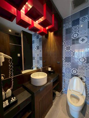 a bathroom with a sink and a toilet and a mirror at Guan Yu Boutique Hotel in Ban Thong Yi