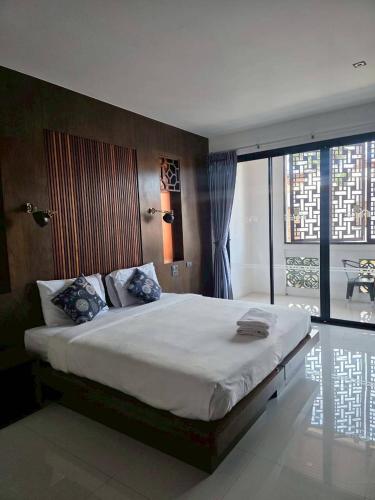 a bedroom with a large bed and a large window at Guan Yu Boutique Hotel in Ban Thong Yi