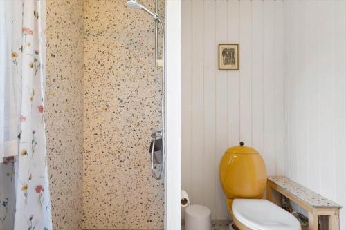 a bathroom with a shower with a yellow toilet at LF15083-Farso-Illeris-153 in Hole