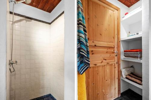 a bathroom with a shower and a wooden door at FA030-Faxe-Bogebakken-6 in Faxe