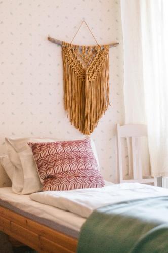 a bed with a basket hanging on a wall at Majatalo Puukarin Pysäkki in Nurmes