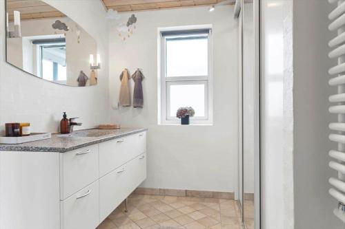 a white bathroom with a sink and a mirror at LF15163-Hojslev-Jelsevej-163 in Lundø