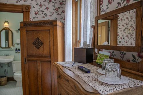a bathroom with a bed and a vanity with a mirror at The Governor's Inn in Ludlow