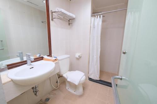 a bathroom with a sink and a toilet and a shower at Grand Orchid Hotel Solo in Solo