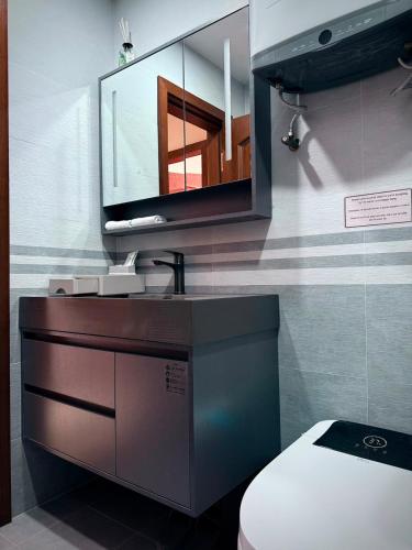 a bathroom with a toilet and a tv on the wall at 2149 Hotel in Khorog