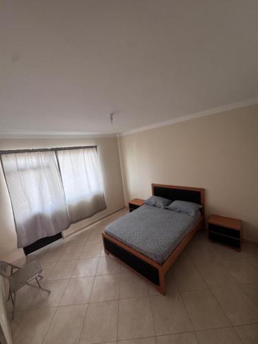 a bedroom with a bed and two windows at Maddox's Place in São Filipe