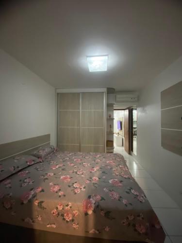 a bedroom with a large bed with flowers on it at Monte Castelo Flat in Sairé