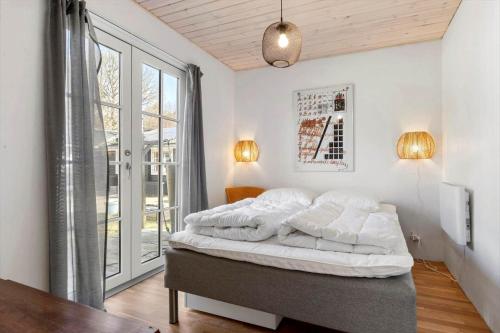 a bedroom with a bed and a large window at 8880-Grenaa-Lyngtoften-49 in Selkær