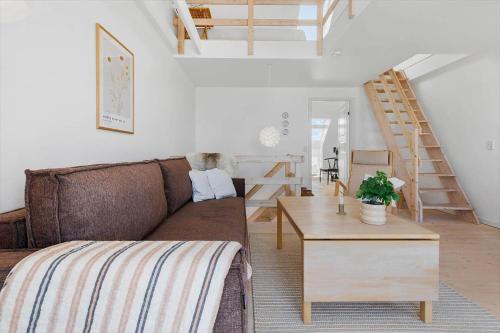 a living room with a brown couch and a wooden table at 8578-Glesborg-Agterspejlet-13 in Bønnerup Strand