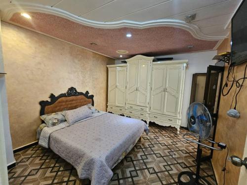 a bedroom with a bed and a fan at Café de Mazagran in Mostaganem