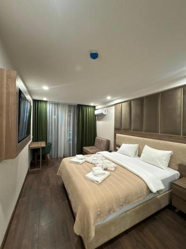 a bedroom with a large bed and a television at Apartment Beach in Itʼkhvisi