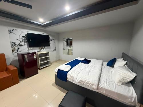 a bedroom with a bed and a flat screen tv at HOTELc3 in Visakhapatnam